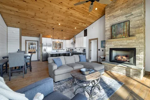 a kitchen with stainless steel appliances granite countertop a refrigerator a sink dishwasher a stove and white countertops with wooden floor