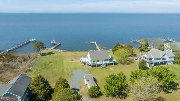 an aerial view of a house with swimming pool and large trees