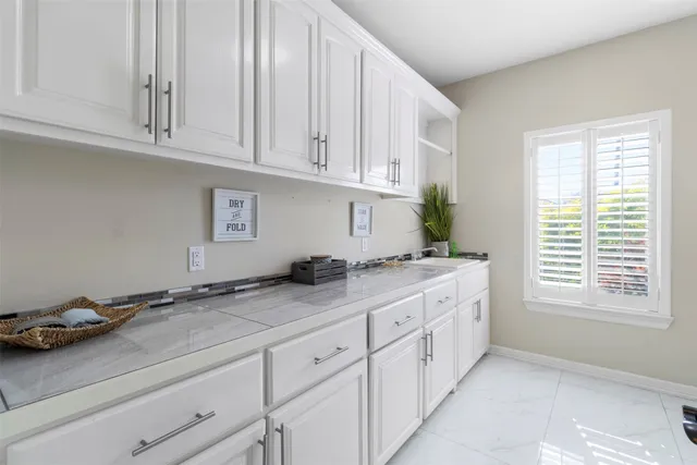 a kitchen with granite countertop white cabinets and white appliances