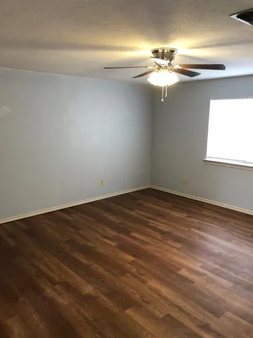 a view of a room with wooden floor and a window