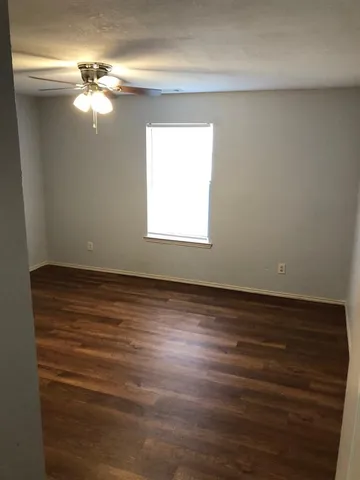 a view of a room with wooden floor and fan