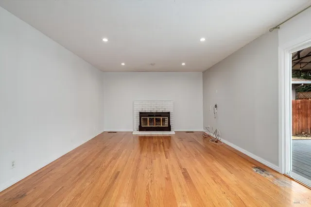 a view of empty room with wooden floor and ceiling fan