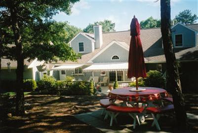 47 Cairn Ridge Road East Falmouth, MA 02536 - Photo 18 of 19 a view of a patio with table and chairs and potted plants