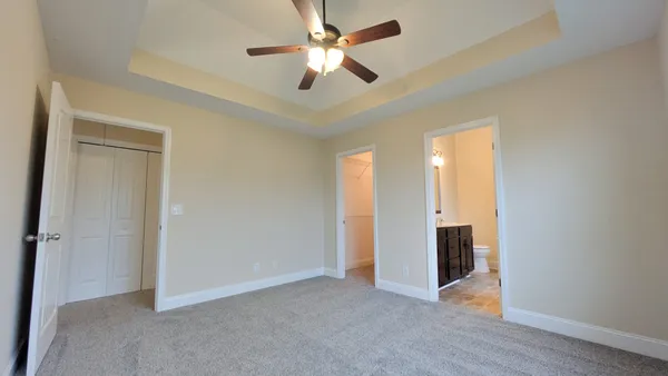 an empty room with closet and a ceiling fan