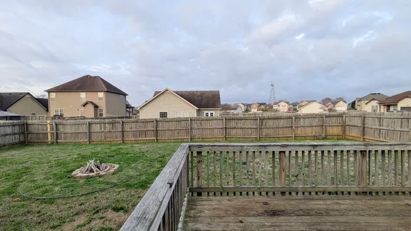 a view of a house with a backyard and a chair