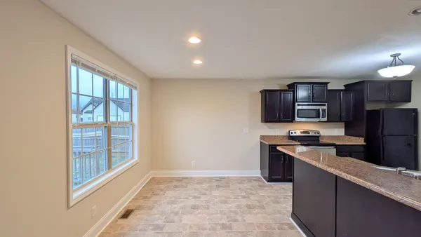 a kitchen with stainless steel appliances granite countertop a refrigerator and a stove top oven