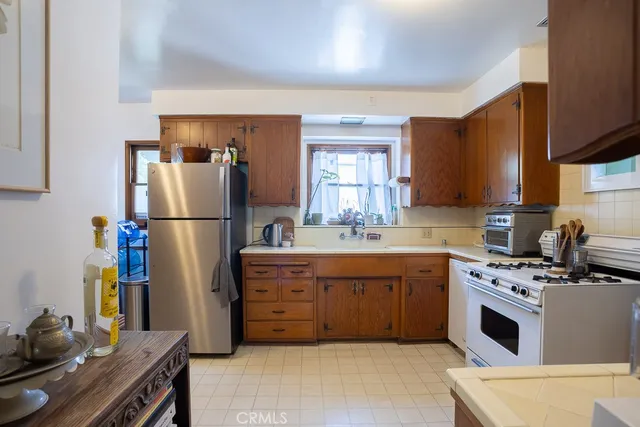 a kitchen with stainless steel appliances granite countertop a stove a sink and a refrigerator
