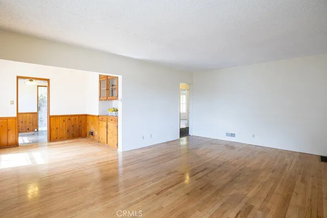 a view of a hallway with wooden floor and furniture