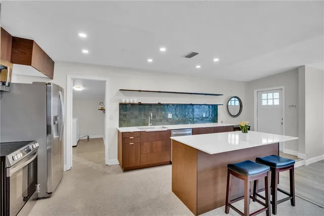 a room with stainless steel appliances granite countertop furniture wooden floor and window