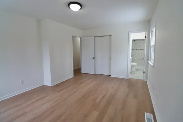 a view of empty room with wooden floor