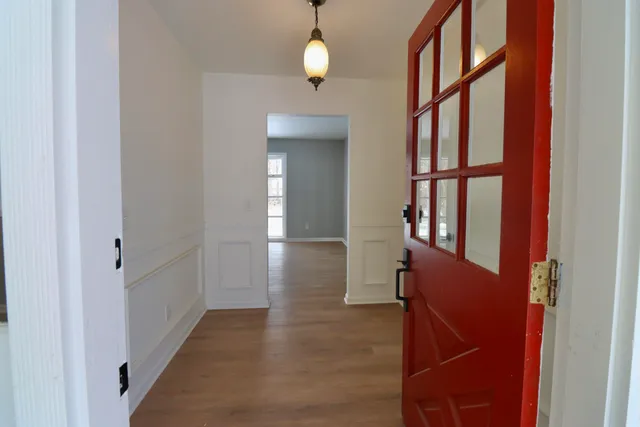 a view of a hallway with wooden floor and staircase