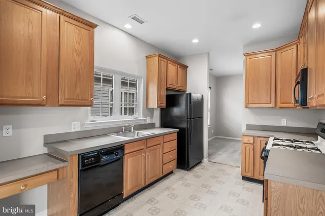 a kitchen with stainless steel appliances granite countertop a refrigerator stove and sink