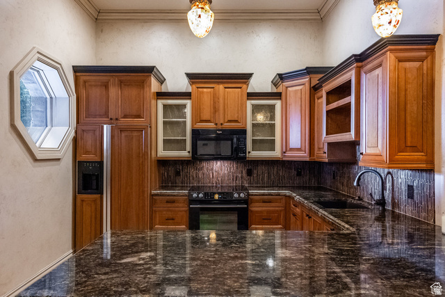 694 West Cephus Road Draper, UT 84020 - Photo 77 of 148 Kitchen featuring wood cabinetry, dark-toned countertops, tile backsplash, built-in appliances, and a unique octagonal window