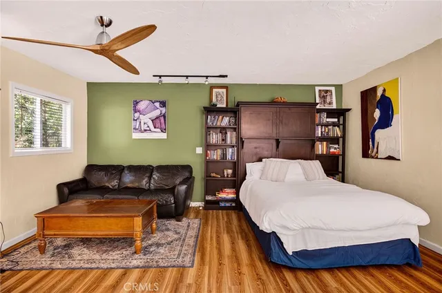 a bedroom with a bed and wooden floor