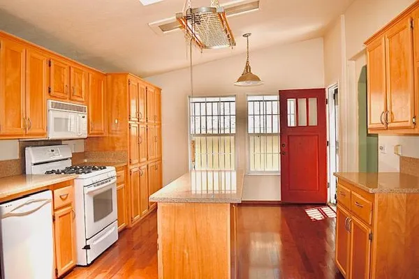 a view of a kitchen with a stove wooden floor and a window