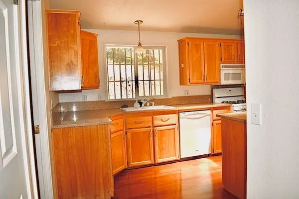 a view of a kitchen with a sink and wooden floor
