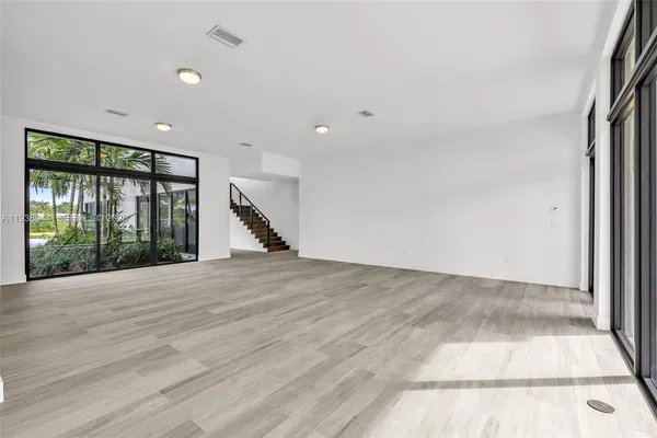 a view of an empty room with glass door and balcony