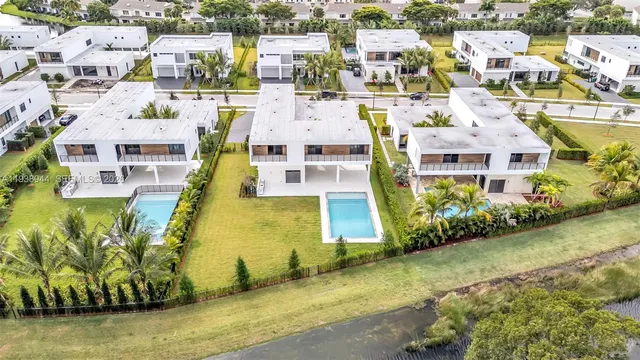 an aerial view of residential houses with outdoor space and swimming pool