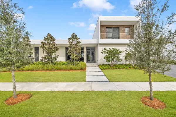 a front view of a house with yard and green space