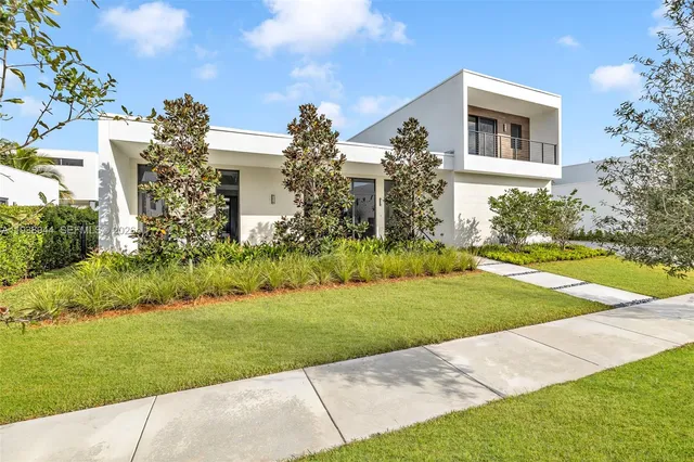 a front view of a house with yard and green space