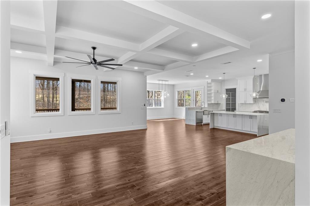 15448 Hopewell Road Milton, GA 30004 - Photo 11 of 125 a view of an empty room with wooden floor and a kitchen