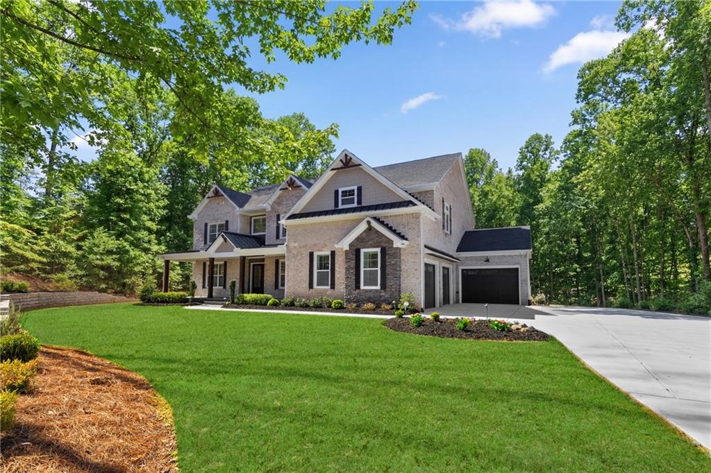 15448 Hopewell Road Milton, GA 30004 - Photo 3 of 125 a front view of a house with a garden and trees