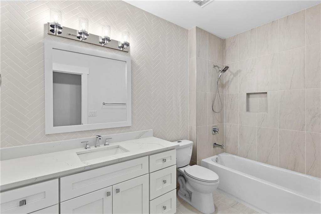 15448 Hopewell Road Milton, GA 30004 - Photo 58 of 125 a bathroom with a toilet a sink a mirror a bathtub and vanity
