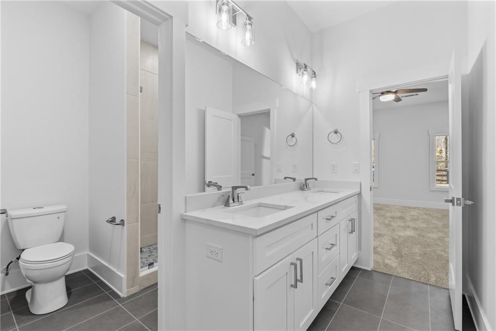 15448 Hopewell Road Milton, GA 30004 - Photo 80 of 125 a spacious bathroom with a toilet sink and a mirror