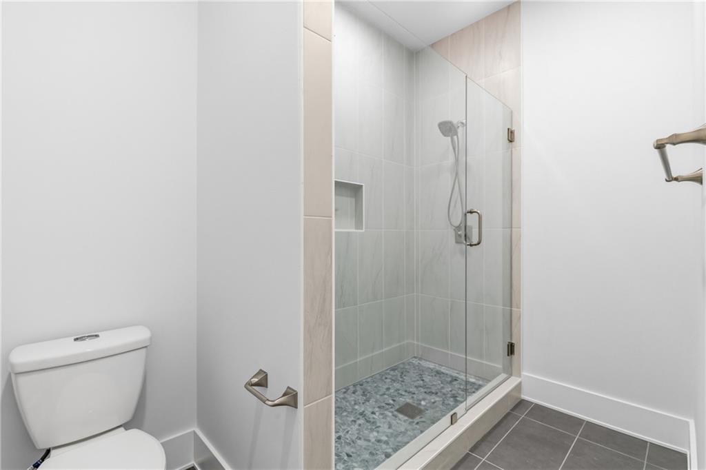 15448 Hopewell Road Milton, GA 30004 - Photo 81 of 125 a bathroom with a granite countertop toilet and a shower