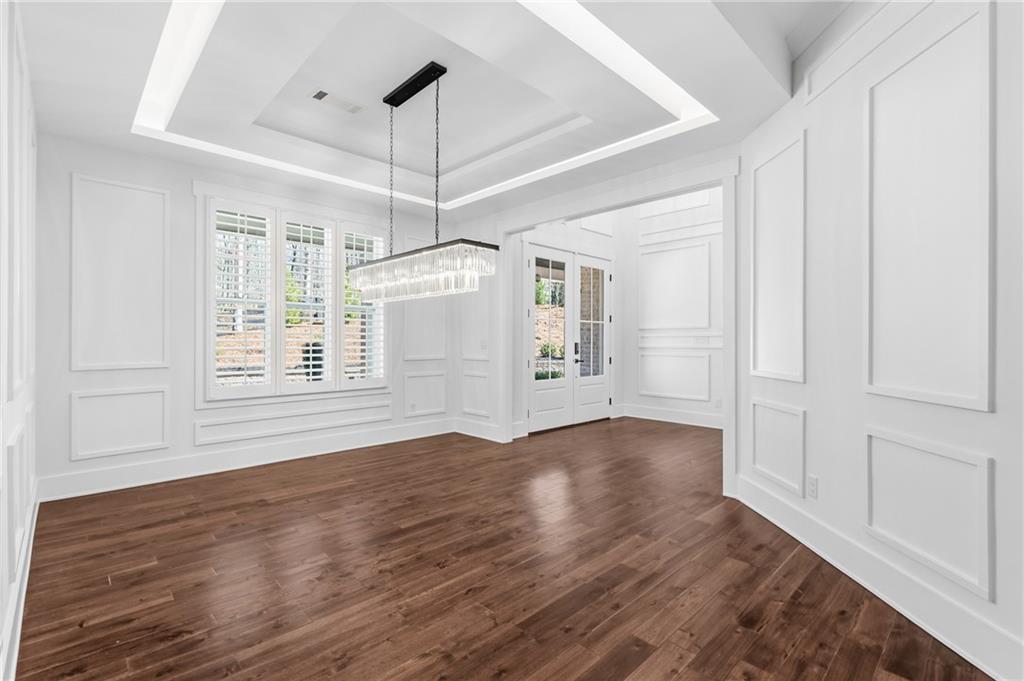 15448 Hopewell Road Milton, GA 30004 - Photo 9 of 125 an empty room with wooden floor chandelier and windows
