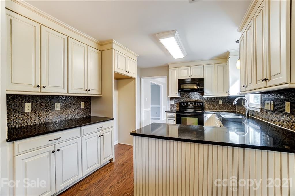 10101 Deer Spring Lane Charlotte, NC 28210 - Photo 12 of 45 a kitchen with granite countertop white cabinets sink and stainless steel appliances