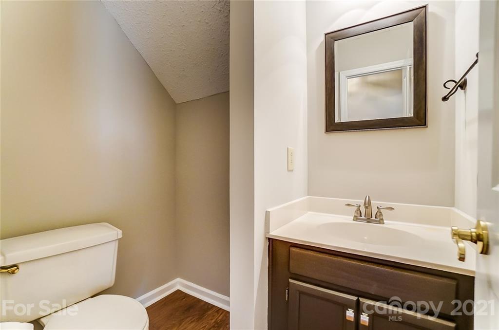10101 Deer Spring Lane Charlotte, NC 28210 - Photo 24 of 45 a bathroom with a toilet a sink and mirror