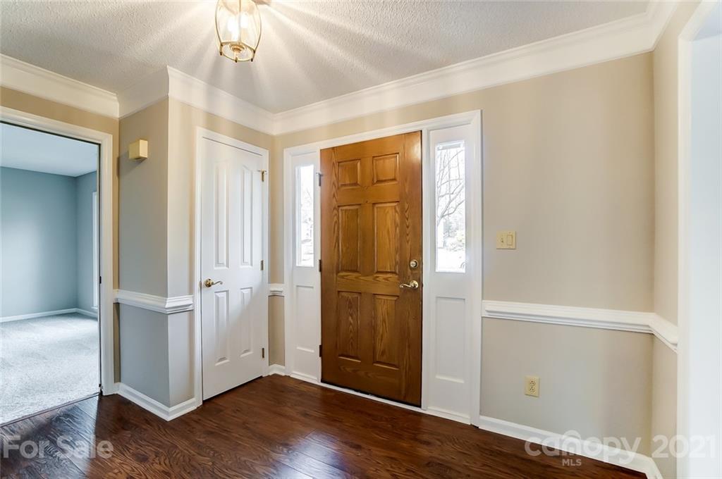 10101 Deer Spring Lane Charlotte, NC 28210 - Photo 4 of 45 an empty room with wooden floor cabinet and staircase
