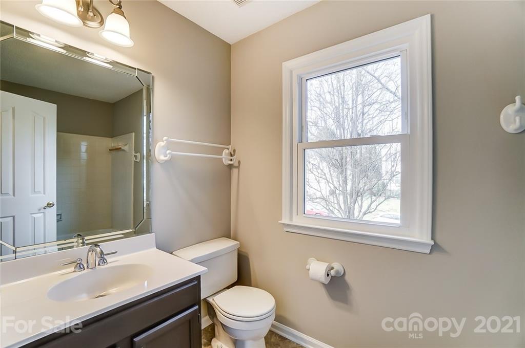10101 Deer Spring Lane Charlotte, NC 28210 - Photo 35 of 45 a bathroom with a granite countertop sink toilet a mirror and a window