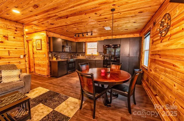 a dining room with stainless steel appliances kitchen island granite countertop a table chairs and a refrigerator