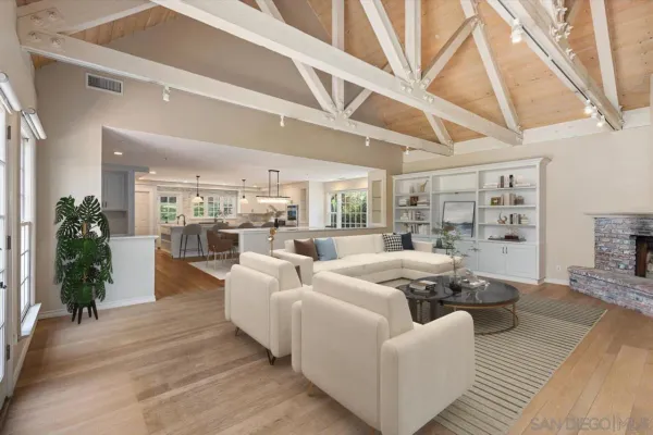 a living room with furniture wooden floor and a large window