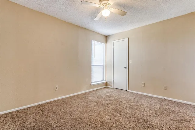 an empty room with a chandelier fan