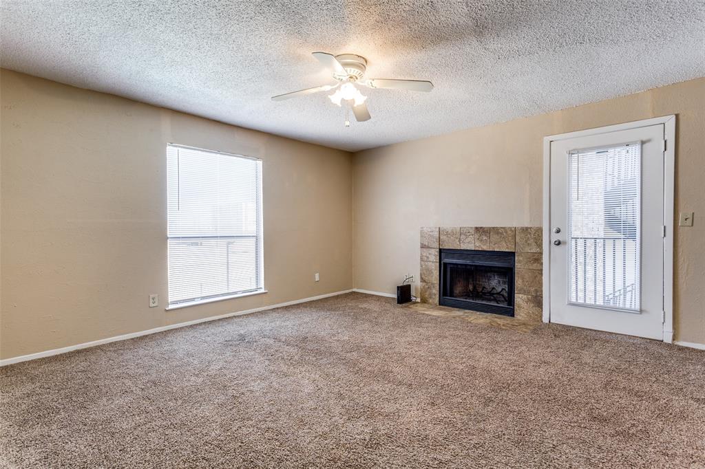 3022 Forest Lane, Unit 218 Dallas, TX 75234 - Photo 3 of 14 an empty room with windows and fireplace