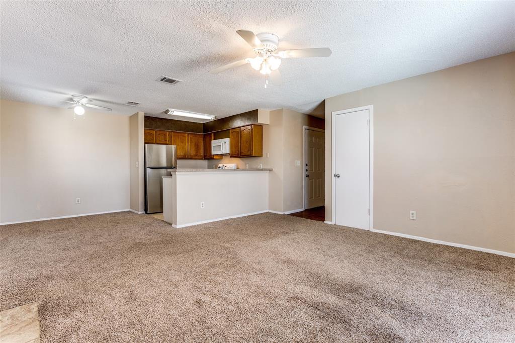 3022 Forest Lane, Unit 218 Dallas, TX 75234 - Photo 5 of 14 a view of a kitchen with a sink and a refrigerator