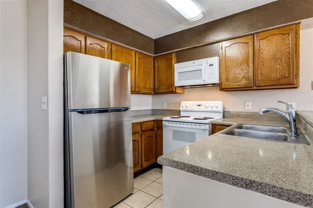 a kitchen with granite countertop a sink stainless steel appliances and cabinets