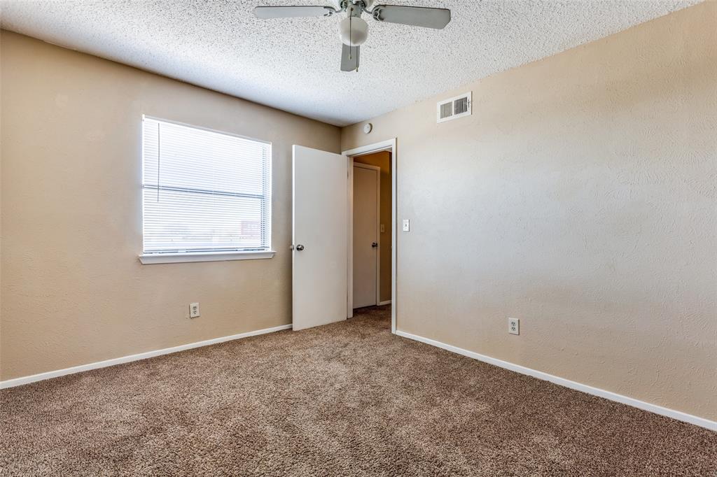 3022 Forest Lane, Unit 218 Dallas, TX 75234 - Photo 10 of 14 an empty room with windows and fan
