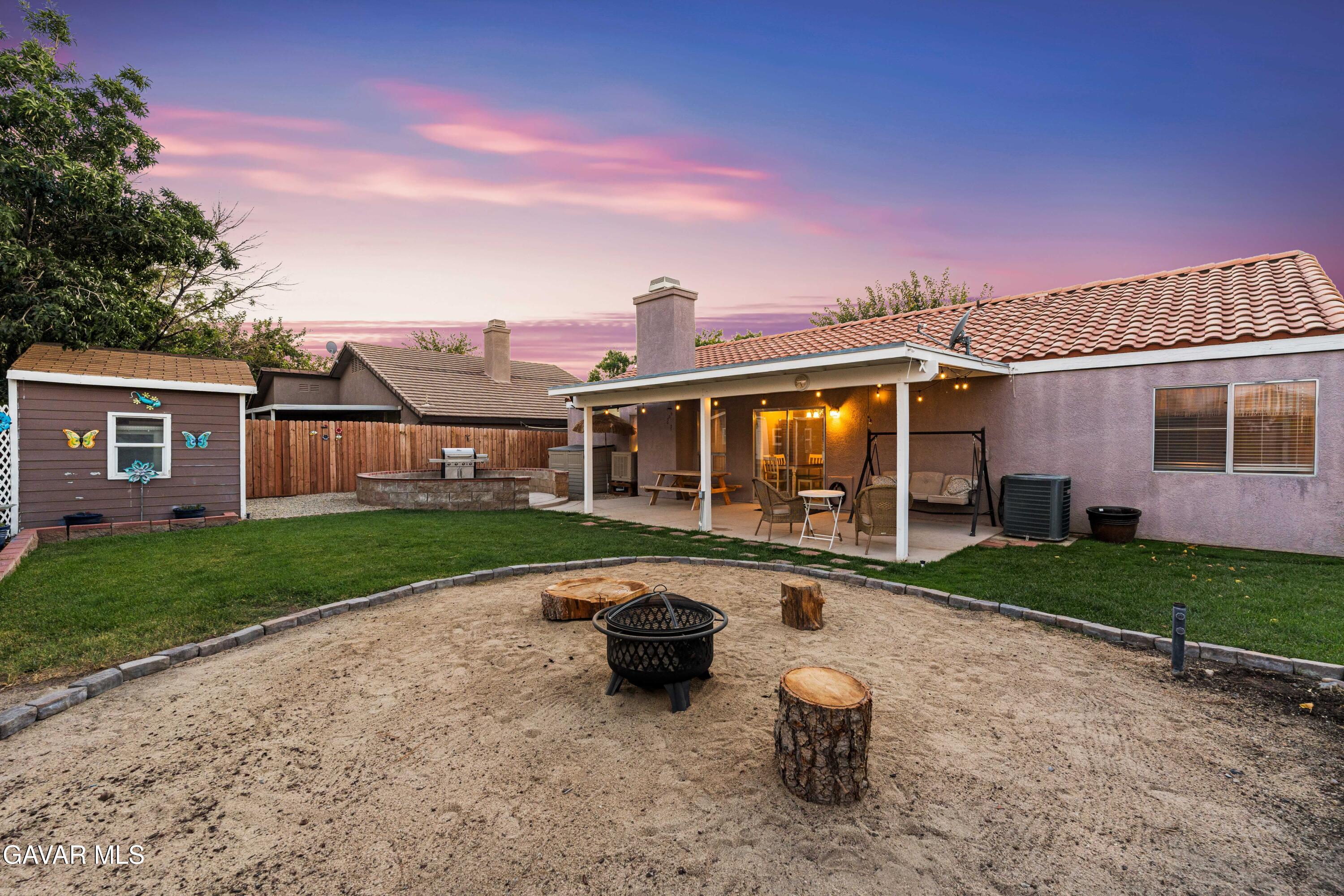 3418 Rodney Street Rosamond, CA 93560 - Photo 29 of 35 a front view of a house with a yard glass top table and chairs