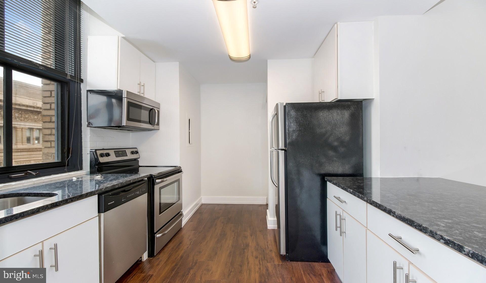 3131 Walnut Street, Unit 2B318 Philadelphia, PA 19104 - Photo 3 of 10 a kitchen with stainless steel appliances granite countertop a refrigerator stove and microwave