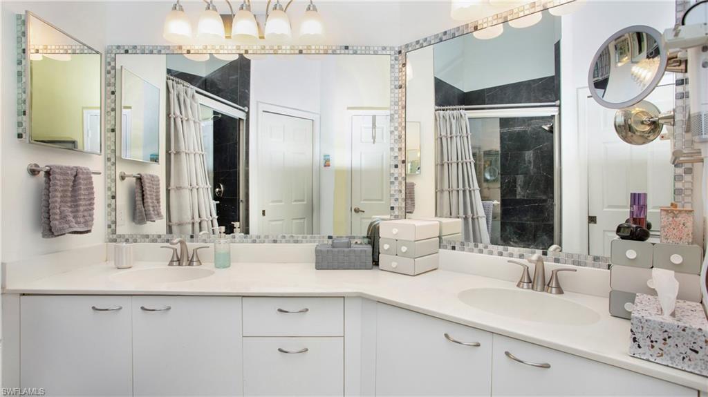 96 Silver Oaks Circle, Unit 1202 Naples, FL 34119 - Photo 12 of 30 a bathroom with a double vanity sink and a mirror