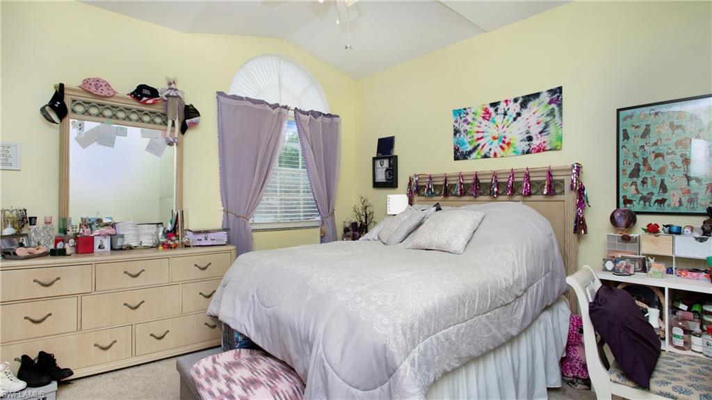 96 Silver Oaks Circle, Unit 1202 Naples, FL 34119 - Photo 16 of 30 a bedroom with a bed a dresser and book shelf