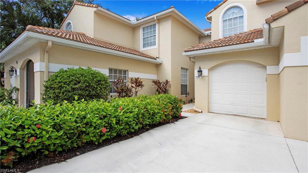 96 Silver Oaks Circle, Unit 1202 Naples, FL 34119 - Photo 19 of 30 a front view of a house with garden