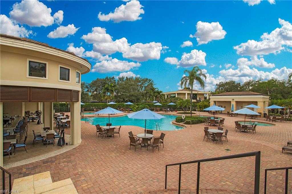 96 Silver Oaks Circle, Unit 1202 Naples, FL 34119 - Photo 29 of 30 a view of a house with patio outdoor dining table and chairs with wooden floor