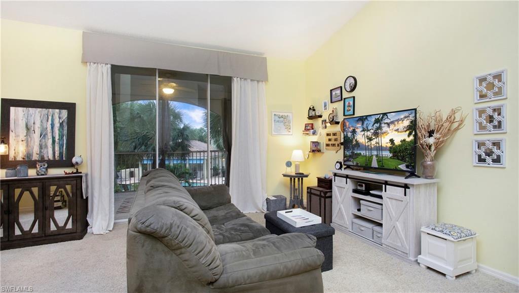 96 Silver Oaks Circle, Unit 1202 Naples, FL 34119 - Photo 6 of 30 a living room with furniture and a flat screen tv