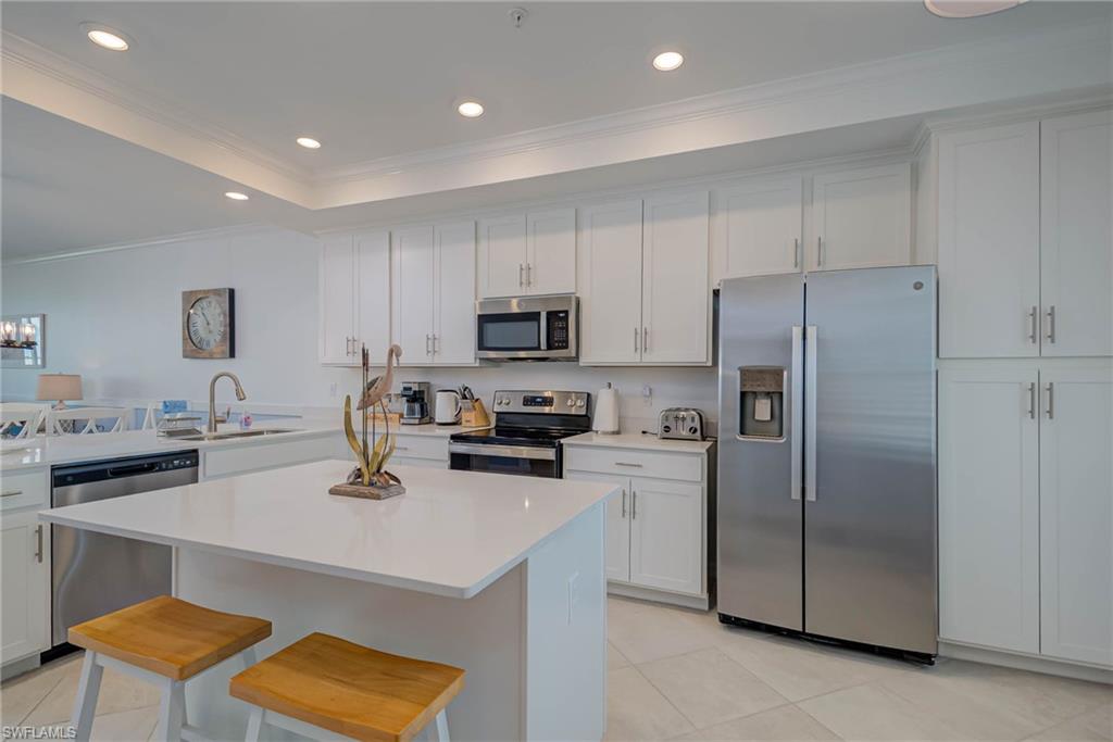 5807 Double Eagle Cir Avenue, Unit 4635 Immokalee, FL 34142 - Photo 11 of 43 a kitchen with a refrigerator a stove and a sink with wooden floor