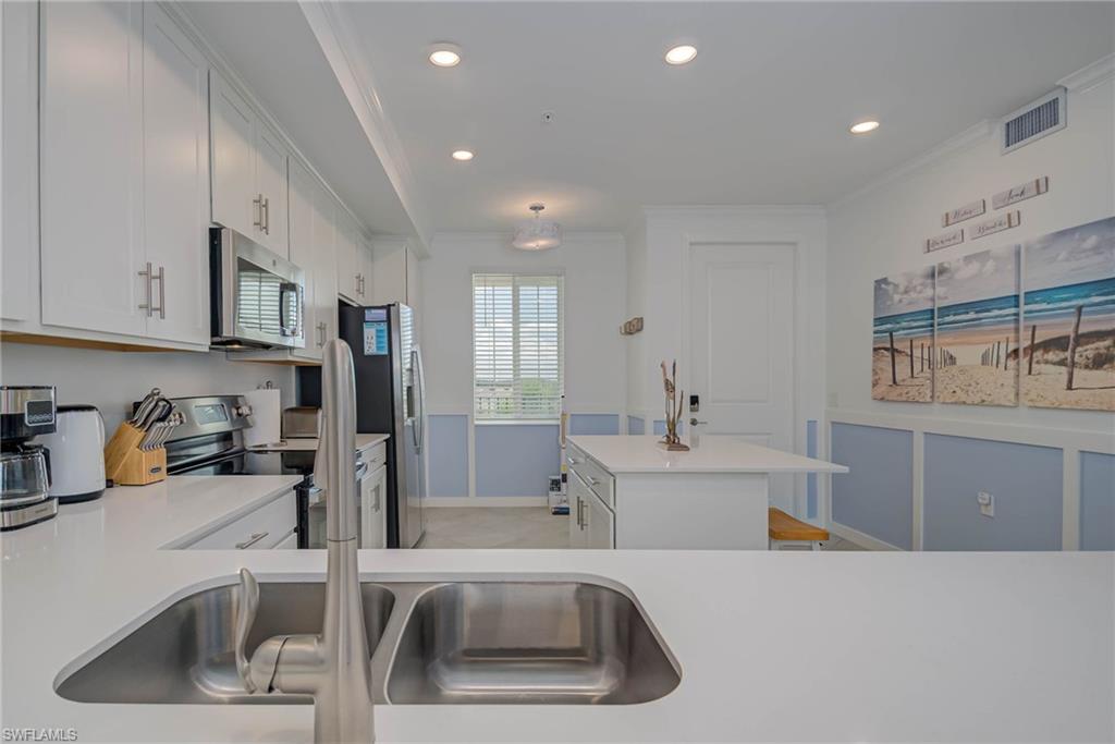 5807 Double Eagle Cir Avenue, Unit 4635 Immokalee, FL 34142 - Photo 13 of 43 a kitchen with a sink and a refrigerator